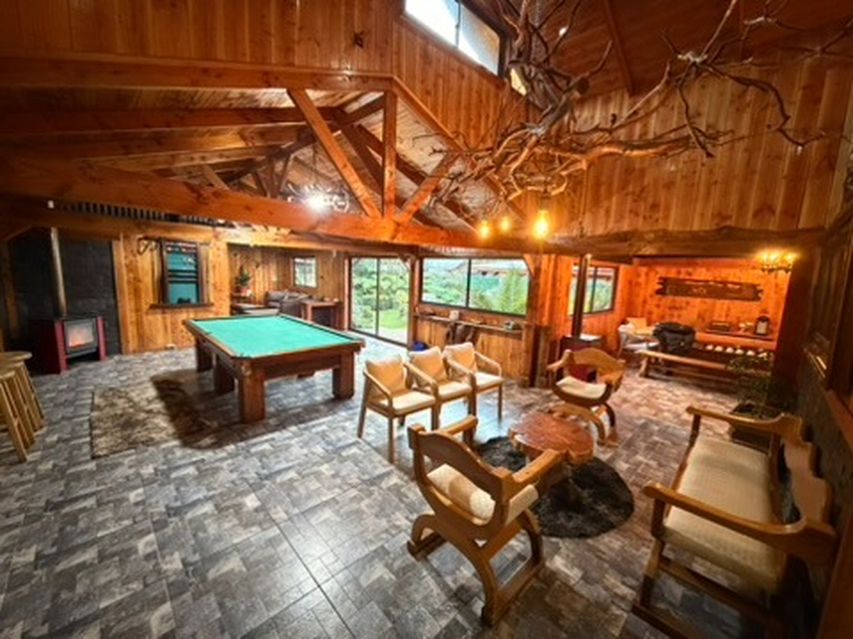 Sala de juegos con mesa de pool y chimenea en Sendas del Volcán, Licán Ray